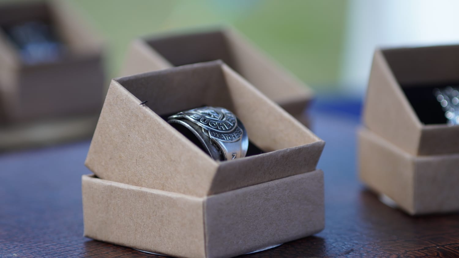 A silver spoon ring resting on antique wood